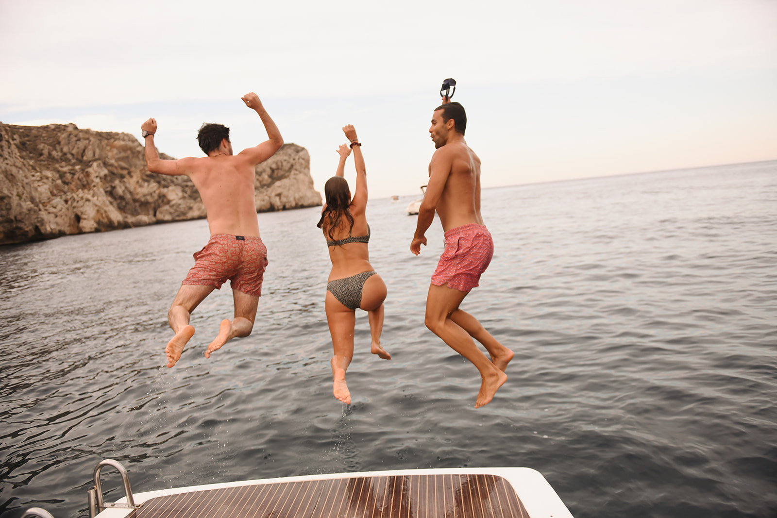 Amigos saltando al agua desde la lancha
